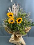 Фото флориста 1: Подсолнухи с лимониумом в джутовой сетке (3 цветка)