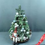 Маленькое фото 1: Новогодняя композиция «Ёлка (пихта) с Дедом Морозом», D 35 см x H 65 см