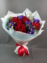 Фото флориста 6: Букет из 9 красных роз и 6 синих ирисов в бумаге с зеленью