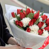Маленькое фото 2: Букет из 24 красных тюльпанов и 9 белых гвоздик в белой пленке с лентой. Сервис доставки цветов AzaliaNow