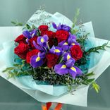 Фото флориста 3: Букет из 9 красных роз и 6 синих ирисов в бумаге с зеленью