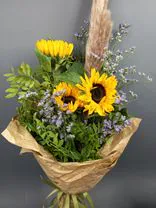 Фото флориста 4: Подсолнухи с лимониумом в джутовой сетке (3 цветка)