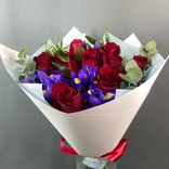 Фото флориста 5: Букет из 9 красных роз и 6 синих ирисов в бумаге с зеленью