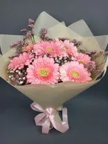 Фото флориста 1: Букет из 7 розовых гербер в кремовой бумаге (букет на День учителя)